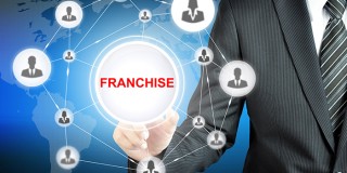 Businessman hand touching FRANCHISE sign on virtual screen
