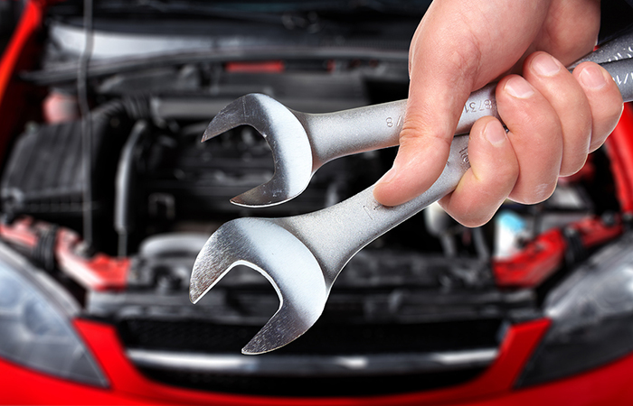 Hand with wrench. Auto mechanic in car repair .